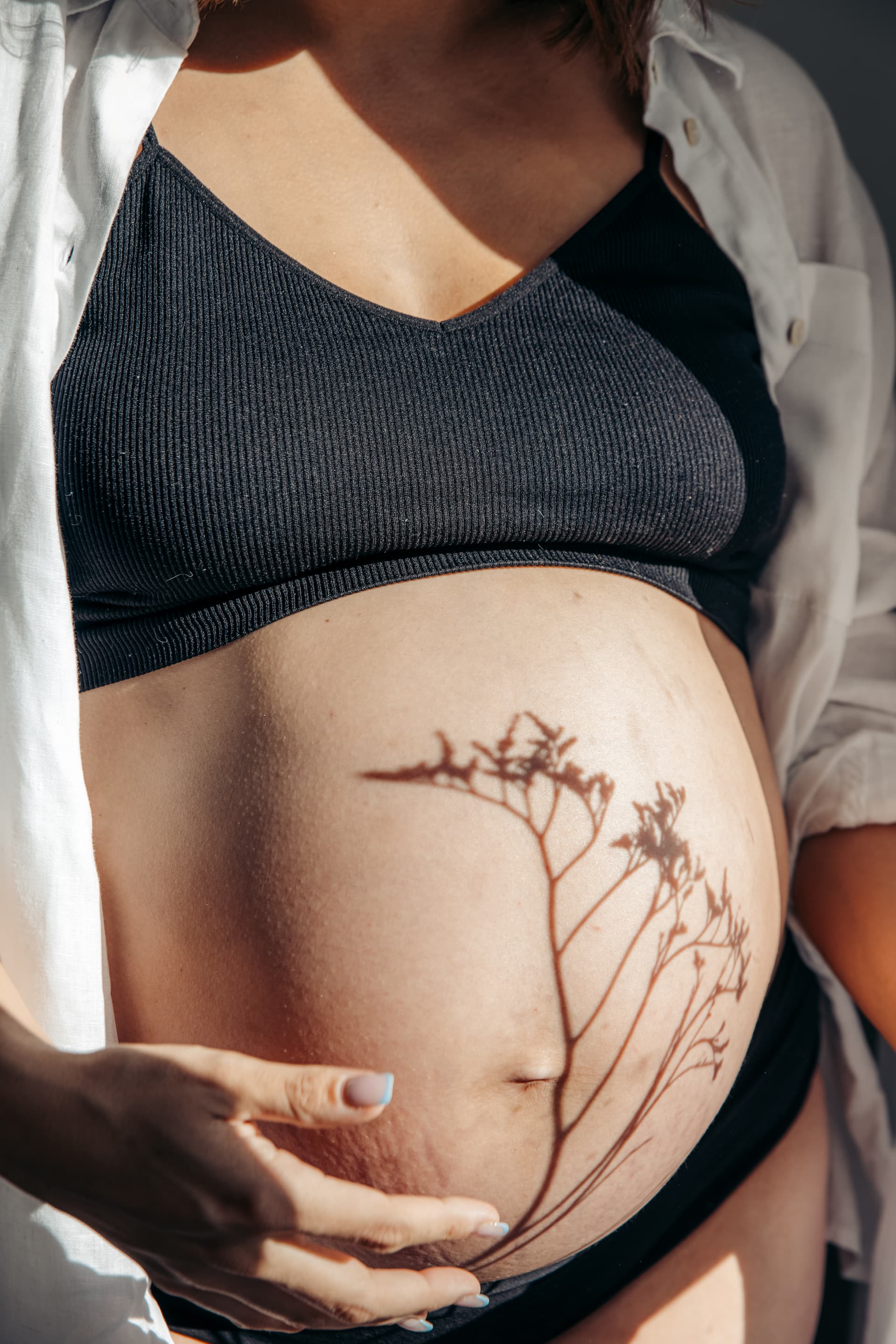 Nicole during pregnancy beneath a flowering tree
