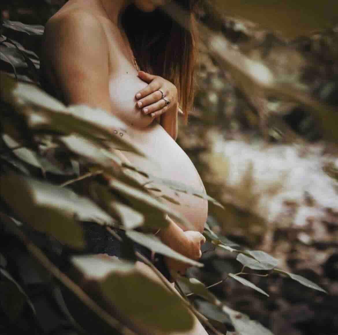 Nicole during pregnancy surrounded by leaves